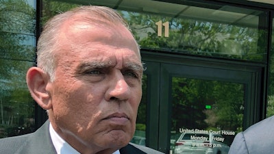 In this May 22, 2019, file photo, Ariel Quiros, left, former owner of Jay Peak Resort, stands outside the federal courthouse in Burlington, Vt., after his arraignment on fraud charges over a failed plan to build a biotechnology plant using foreign investors' money. The Miami businessman, accused of being the mastermind behind a massive fraud case involving foreign investors' money in Vermont developments, is expected to plead guilty in next week in a plea deal in which prosecutors are seeking a sentence of more than eight years in prison.