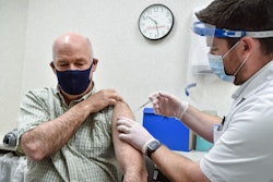 In this April 1, 2021 file photo, Montana Gov. Greg Gianforte receives a shot of the Pfizer COVID-19 vaccine from pharmacist Drew Garton at a Walgreen's pharmacy in Helena, Mont. While large companies across the U.S. have announced that the COVID-19 vaccine will be required for their employees to return to work in-person, there is one state where such requirements are banned: Montana.