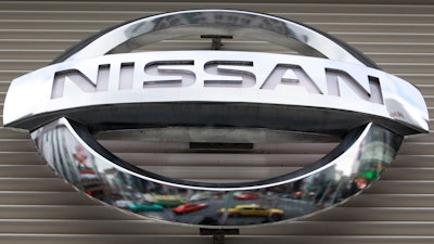 In this Feb. 8, 2012, file photo, vehicles are reflected on the logo of the Nissan Motors Co. at a showroom in Tokyo's Ginza shopping district. Nissan says its huge factory in Smyrna, Tennessee, will close for two weeks starting Monday, Aug. 16, 2021 due to computer chip shortages brought on by a coronavirus outbreak in Malaysia.
