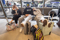 Stranded travelers sleep on the seats of the ticketing waiting area, Tuesday, Aug. 3, 2021. at Philadelphia International Airport in Philadelphia.