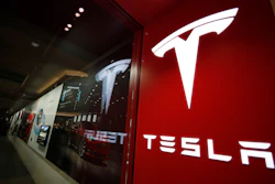 This Feb. 9, 2019, file photo shows a sign bearing the company logo outside a Tesla store in Cherry Creek Mall in Denver. A Tesla using its partially automated driving system slammed into a Florida Highway Patrol cruiser Saturday, Aug. 28, 2021 on an interstate near downtown Orlando and narrowly missed its driver, who had pulled over to assist a disabled vehicle.