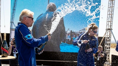 A majority of people think that space endeavors are good for humanity in the long term but for now will mostly benefit the incredibly rich, like Richard Branson, seen here celebrating after his successful flight.