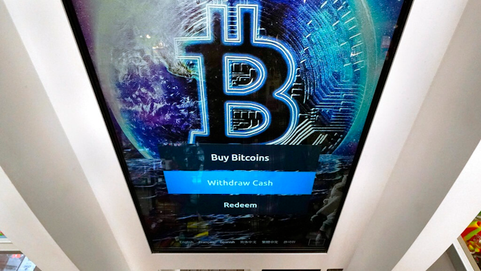 In this Feb. 9, 2021, file photo, the Bitcoin logo appears on the display screen of a cryptocurrency ATM at the Smoker's Choice store in Salem, N.H. China’s central bank on Friday, Sept. 24, 2021, declared all transactions involving Bitcoin and other virtual currencies illegal, stepping up a campaign to block use of unofficial digital money.