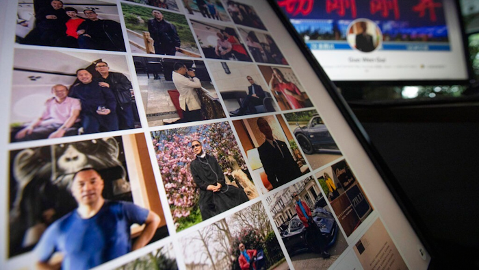 In this Aug. 21, 2020, file photo, Facebook pages from self-exiled Chinese tycoon Guo Wengui's account are seen on computer screens in Beijing. Three companies linked to Guo, a prominent critic of his country’s ruling Communist Party, have agreed to pay $539 million to settle charges they conducted an illegal securities offering, according to regulators.