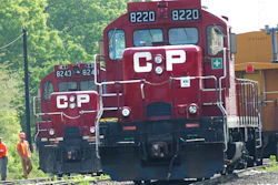 In this May 23, 2012 photo, surveyors work next to Canadian Pacific Rail trains which are parked on the train tracks in Toronto.