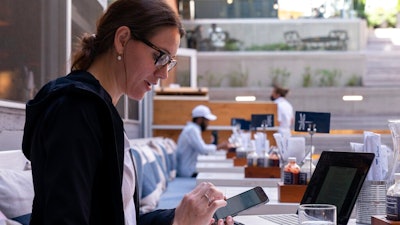 Baylee Bowers pays for her lunch using her cell phone at Bartaco in Arlington, Va., Sept. 2, 2021.