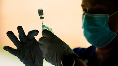 A syringe is prepared with the Pfizer COVID-19 vaccine at a clinic at the Reading Area Community College in Reading, Pa., Tuesday, Sept. 14, 2021.