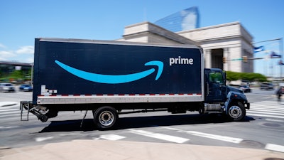 An Amazon truck drives in in Philadelphia, Friday, April 30, 2021. Amazon wants to hire 125,000 delivery and warehouse workers and said Tuesday, Sept. 14, 2021 that it is paying new hires an average of $18 an hour in a tight job market as more people shop online. The company is also offering pay sign-on bonuses of $3,000 in some parts of the country.