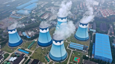 Steam billows out of the cooling towers at a coal-fired power station in Nanjing in east China's Jiangsu province on Monday, Sept. 27, 2021. Global shoppers face possible shortages of smartphones and other goods ahead of Christmas after power cuts to meet government energy use targets forced Chinese factories to shut down and left some households in the dark.