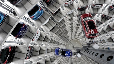 In this March 14, 2017 file photo Volkswagen cars are lifted inside a delivery tower of the company in Wolfsburg, Germany. German automaker Daimler on Friday dismissed a “cease and desist” demand from two environmental groups to commit to ending the sale of combustion engine vehicles by 2030.