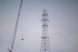 In this Friday, Sept. 3, 2021, file photo, Entergy contractors prepare to detonate transmission lines that fell into the Mississippi River Harahan, in New Orleans, after a tower collapsed during Hurricane Ida.