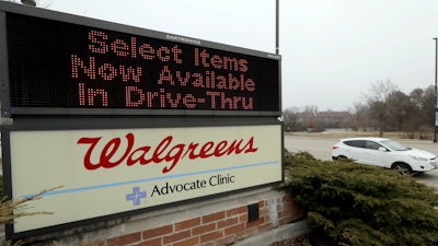 In this March 27, 2020, file photo, a Walgreens sign is displayed outside the store in Wheeling, Ill. Walgreens will hike starting pay to $15 an hour beginning in October, as employers across the United States continue boosting wages to attract workers.