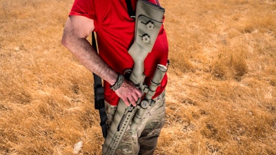 Firearms instructor Michael Palombo holds a Springfield Armory M25 rifle during field testing to measure radio frequency identification signal range in Hickman, Calif., on Sunday, June 6, 2021. Palombo inserted an RFID tag into the rifle for the test.