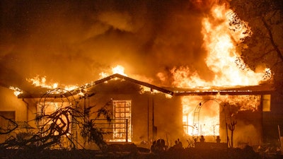 In this Sept. 27, 2020, file photo, a house burns on Platina Road at the Zogg Fire near Ono, Calif. Pacific Gas & Electric has been charged with manslaughter and other crimes, Friday, Sept. 24, 2021, in a Northern California wildfire last year that killed four people and destroyed hundreds of homes.