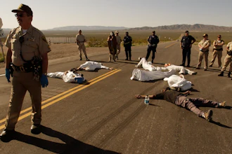 In this May 11, 2003, file photo, protesters lie on the pavement opposed to the proposed Yucca Mountain nuclear storage facility and weapons testing after crossing the line into the Nevada Test Site at Mercury, Nev., and were arrested for trespassing about 70 miles north of Las Vegas. A bipartisan group of lawmakers is renewing the push to expand a federal compensation program for radiation exposure following uranium mining and nuclear testing carried out during the Cold War.
