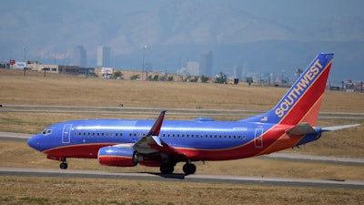 With the city skyline in the background, a Southwest Airlines jetliner taxis to the west runway for takeoff from Denver International Airport, Tuesday, Aug. 24, 2021, in Denver. The pilots’ union is suing Southwest Airlines, saying that rules the airline put into place before and during the pandemic have changed pay rates and working rules, in violation of federal labor law.