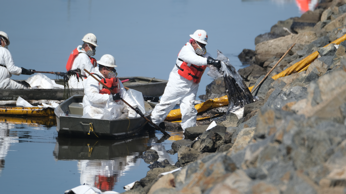 Cleanup contractors unload collected oil in plastic bags trying to stop further oil crude incursion into the Wetlands Talbert Marsh in Huntington Beach, Calif., Sunday, Oct. 3, 2021. One of the largest oil spills in recent Southern California history fouled popular beaches and killed wildlife while crews scrambled Sunday to contain the crude before it spread further into protected wetlands.