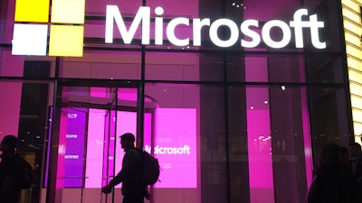 In this Nov. 10, 2016, file photo, people walk past a Microsoft office in New York. Microsoft on Oct. 7, 2021, says Russia once again accounted for most state-sponsored hacking, with a 58% share of intrusion attempts it detected in the past year. The targets were mostly government agencies — in the United States, followed by Ukraine, Britain and European NATO members.