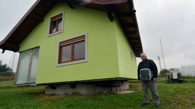 Vojin Kusic's stands in front of his rotating house in a town of Srbac, northern Bosnia, Sunday, Oct. 10, 2021.
