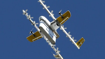 A Wing drone hovers before lowering a package to the ground by tether, Christiansburg Va., Oct. 18, 2019.