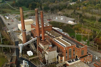 Smokestacks from the Greenidge Generation power plant tower above nearby homes, Friday, Oct. 15, 2021, in Dresden, N.Y.