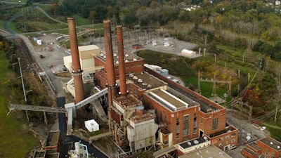 Smokestacks from the Greenidge Generation power plant tower above nearby homes, Friday, Oct. 15, 2021, in Dresden, N.Y.