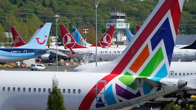 In this April 26, 2021, file photo Boeing 737 Max airplanes sit parked in a storage lot, near Boeing Field in Seattle. The Boeing Co. told employees, Tuesday, Oct. 12, 2021, that they must be vaccinated against COVID-19 or possibly be fired.
