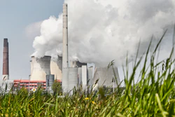 In this Thursday, April 29, 2021 file photo, a coal-fired RWE power plant steams on a sunny day in Neurath, Germany. The International Energy Agency is urging governments to make stronger commitments to cut greenhouse gas emissions at an upcoming U.N. climate summit.