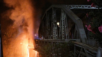 Flames engulf the Industry Bridge in Rome, early Sunday, Oct. 3, 2021. A blaze, possibly sparked by a gas canister explosion, destroyed part of an historic bridge spanning the Tiber River in Rome before firefighters extinguished the flames early Sunday.