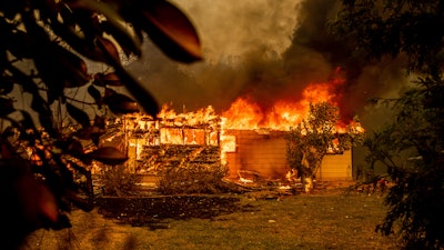 In this Sept. 23, 2021, file photo, flames consume a house near Old Oregon Trail as the Fawn Fire burns north of Redding in Shasta County, Calif. U.S. officials have approved a long-lasting fire retardant that could significantly aid in fighting increasingly destructive wildfires.