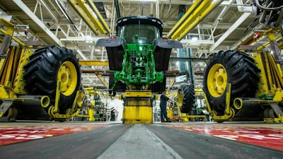 Wheels are attached as workers assemble a tractor at John Deere's Waterloo, Iowa assembly plant, April 9, 2019.
