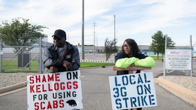 Larry Gamble, who has worked at the Kellogg plant for 13 years, and Sharnita Childress, who has worked at the plant for 8 years, picket with other union workers outside of the plant in Battle Creek, Mich. on Tuesday, Oct. 19, 2021. Around 1,400 union workers from Michigan, Tennessee, Pennsylvania and Nebraska have been on strike for the past two weeks.