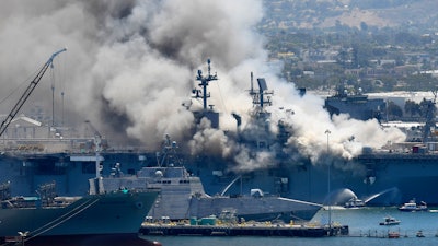In this July 12, 2020, file photo, smoke rises from the USS Bonhomme Richard at Naval Base San Diego in San Diego, after an explosion and fire on board the ship at Naval Base San Diego. A Navy report has concluded there were sweeping failures by commanders, crew members and others that fueled the July 2020 arson fire that destroyed the USS Bonhomme Richard, calling the massive five-day blaze in San Diego preventable and unacceptable.