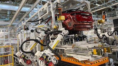 Robotic arms put in the electric vehicle powertrain into the Ariya model in the assembly line at Nissan's Tochigi plant in Kaminokawa town, Tochigi prefecture, Japan, Friday, Oct. 8, 2021.