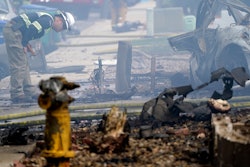A fire official looks over the scene of a small plane crash, Monday, Oct. 11, 2021, in Santee, Calif. At least two people were killed and two others were injured when the plane crashed into a suburban Southern California neighborhood, setting two homes ablaze, authorities said.