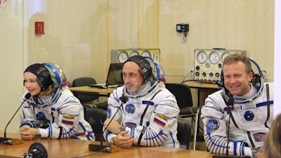 In this handout photo released by Roscosmos, actress Yulia Peresild, left, film director Klim Shipenko, right, and cosmonaut Anton Shkaplerov speak with their relatives through a safety glass prior the launch at the Baikonur Cosmodrome, Kazakhstan, Tuesday, Oct. 5, 2021.
