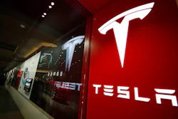 This Feb. 9, 2019, file photo shows a sign bearing the company logo outside a Tesla store in Cherry Creek Mall in Denver. Tesla says it delivered 241,300 electric vehicles in the third quarter in 2021, even as it wrestled with a global shortage of computer chips that has hit the entire auto industry. The Palo Alto, California, company’s sales from July through September beat Wall Street estimates.