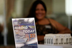 A hiring sign is placed at a booth for prospective employers during a job fair Wednesday, Sept. 22, 2021, in the West Hollywood section of Los Angeles. The number of Americans applying for unemployment aid rose last week for a second straight week to 351,000, a sign that the delta variant of the coronavirus may be disrupting the job market’s recovery, at least temporarily.