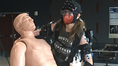 Doctoral student Sarah Hopko is wearing an exoskeleton while performing patient handling tasks. Her brain activity is being tracked using Near Infrared Spectroscopy, gaze behavior is being tracked using eye tracking and muscle activity through electromyographic sensors.