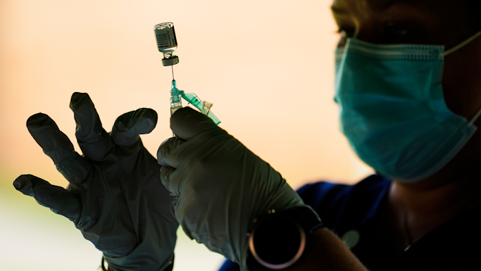 In this Sept. 14, 2021, file photo, a syringe is prepared with the Pfizer COVID-19 vaccine at a clinic at the Reading Area Community College in Reading, Pa. Companies with at least 100 workers will be required to give employees paid time off to get vaccinated against COVID-19 and paid sick leave if they have side effects from the shots. That's according to a Biden administration official who spoke Monday, Nov. 1, about pending vaccine-mandate rules from OSHA, the Occupational Safety and Health Administration.