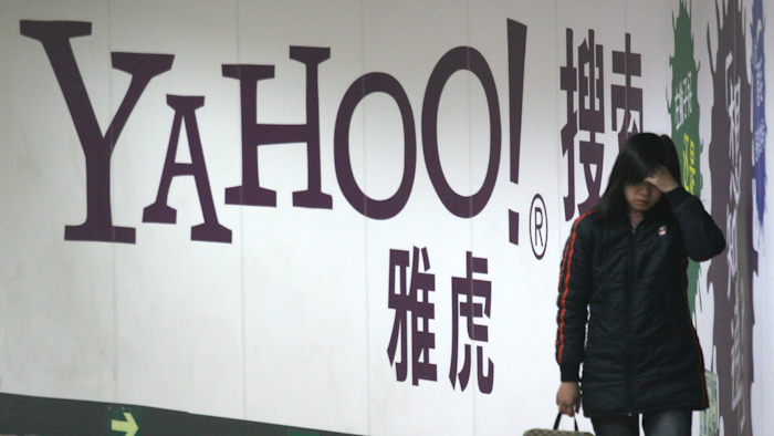 A woman walks past a Yahoo billboard in a Beijing subway in this March 17, 2006. Yahoo Inc. on Tuesday, Nov. 2, 2021 said it plans to pull out of China, citing an 'increasingly challenging business and legal environment.'