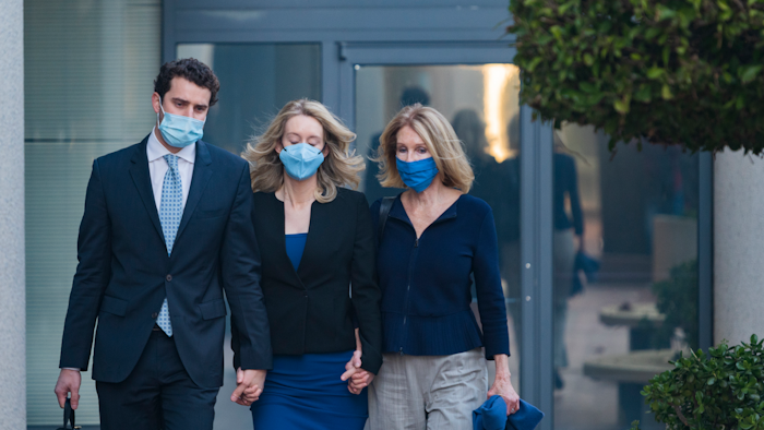 Elizabeth Holmes, center, walks into federal court in San Jose, Calif., Nov. 22, 2021.