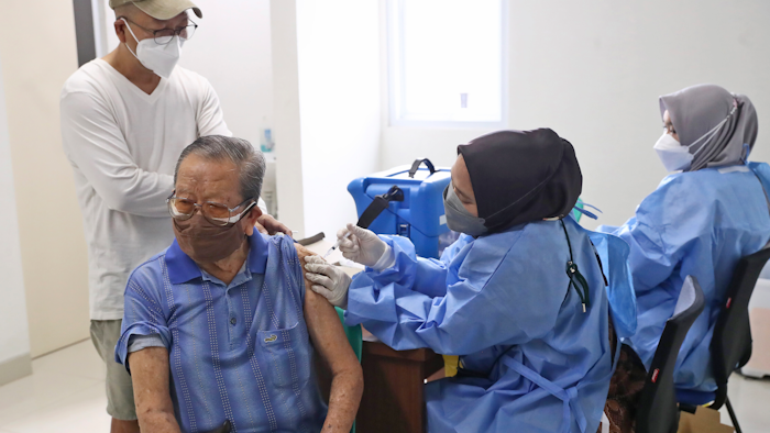 An elderly man receives a shot of the COVID-19 vaccine during a vaccination campaign at a community health center in Tangerang on the outskirts of Jakarta, Indonesia, Thursday, Oct. 28, 2021. Biotechnology company Novavax said Monday that Indonesia has given the world's first emergency use authorization for its COVID-19 vaccine, which uses a different technology than currently used shots.