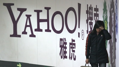 A woman walks past a Yahoo billboard in a Beijing subway in this March 17, 2006. Yahoo Inc. on Tuesday, Nov. 2, 2021 said it plans to pull out of China, citing an 'increasingly challenging business and legal environment.'