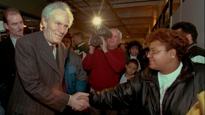 Aaron Feuerstein, left, president and owner of Malden Mills Industries Inc., in Methuen, Mass., shakes hands with workers on Jan. 11, 1996, in Lawrence, Mass.