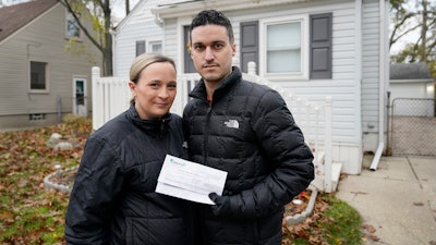 Nicole and Simon Obarto with a lead and copper analysis from the Oakland County Health Division, Royal Oak, Mich., Nov. 18, 2021.