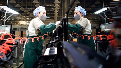 In this photo released by Xinhua News Agency, a worker cleans a piano at a production factory of Parsons Music Corporation in Yichang in central China's Hubei Province, Nov. 23, 2021. China's manufacturing activity rebounded in November as orders improved and power shortages eased, a survey showed Tuesday, Nov. 30, 2021.