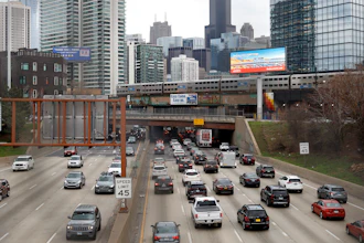 In this March 31, 2021 file photo, traffic flows along Interstate 90 highway as a Metra suburban commuter train moves along an elevated track in Chicago. Congress has created a new requirement for automakers: find a high-tech way to keep drunken people from driving cars.