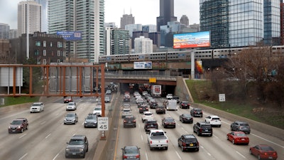 In this March 31, 2021 file photo, traffic flows along Interstate 90 highway as a Metra suburban commuter train moves along an elevated track in Chicago. Congress has created a new requirement for automakers: find a high-tech way to keep drunken people from driving cars.