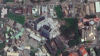 This satellite image provided by Maxar Technologies shows the close up of a collapsed building, center, in Lagos, Nigeria on Wednesday, Nov. 3, 2021. The 21-story luxury apartment building under construction toppled Monday and it took several hours for officials to launch the rescue effort.